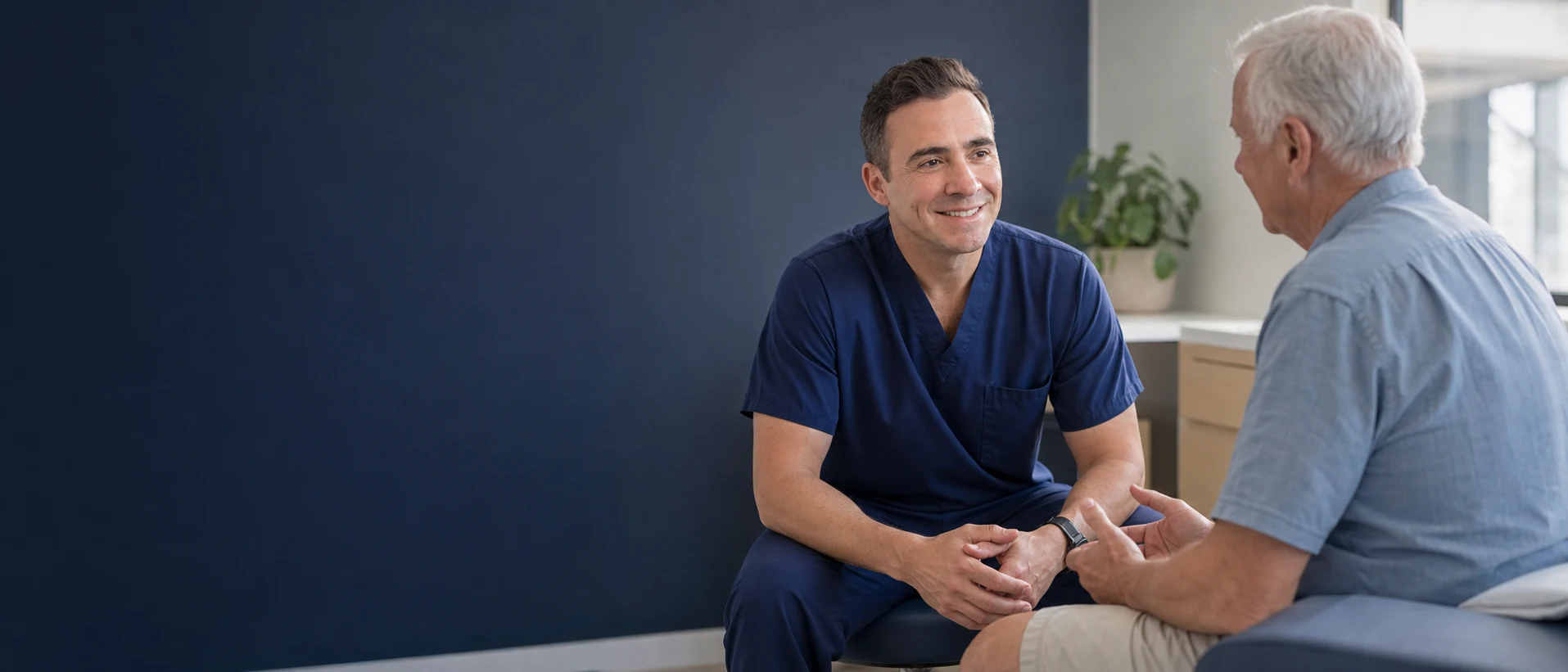 David Mantilla listening as an older adult patient describes leg discomfort